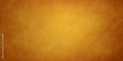 orange golden brown abstract grunge background with light in the center and darkening at the edges