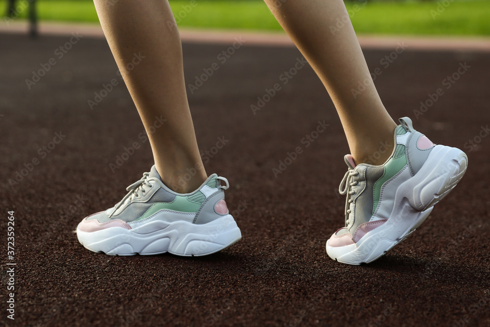 beautiful sports sneakers on women's legs. beautiful sports sneakers on women's legs.
