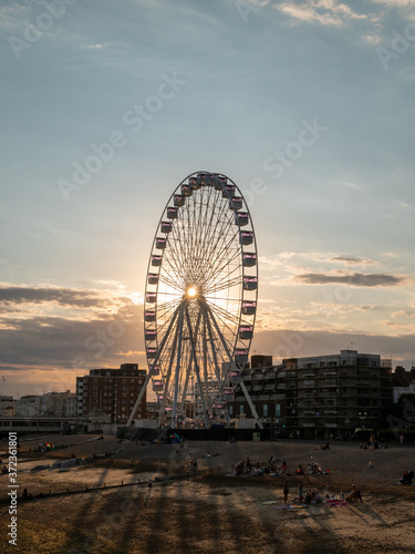 Sun shining through Ferris wheel during sunset 
