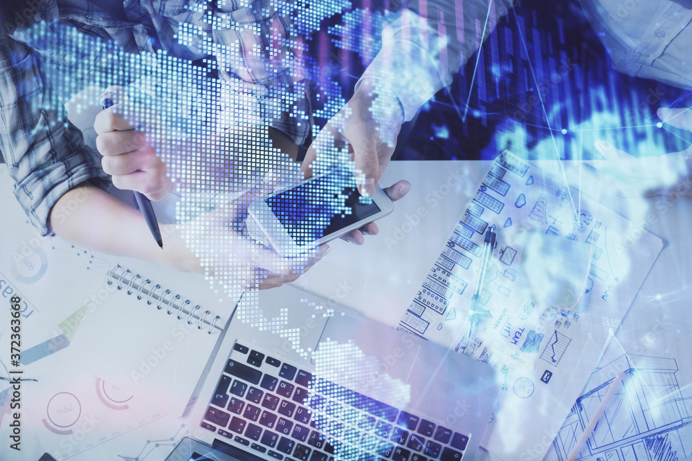 Double exposure of forex graph drawing and man and woman working together holding and using a mobile device. Trade concept. Double exposure of forex graph drawing and man and woman working together holding and using a mobile device. Trade concept.