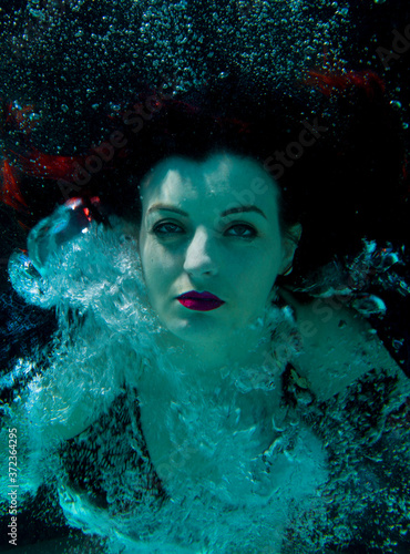 woman underwater posing with bubbles