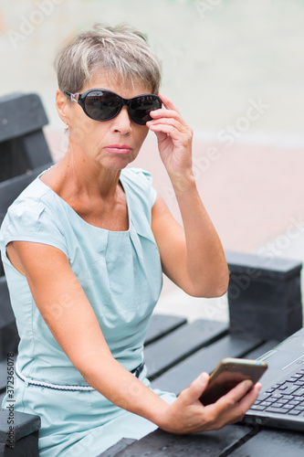 Fashion business senior woman with phone in blue dress  photo