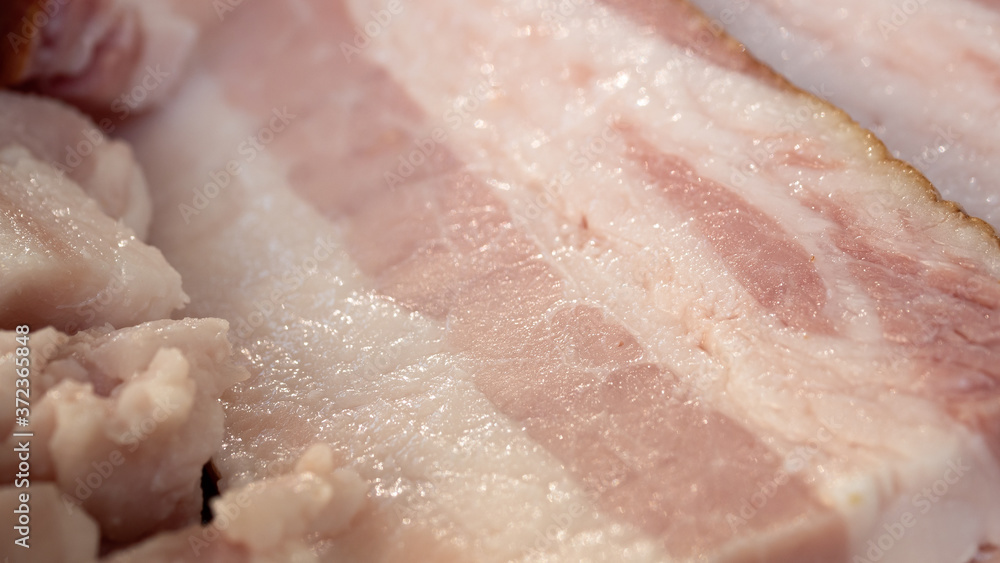 Smoked bacon meat with lots of fat on it in an extreme close up. Smoked bacon meat with lots of fat on it on a wooded board ready to be carved.
The meat is salt-cured and from a pig's belly or back. Smoked bacon meat with lots of fat on it in an extreme close up. Smoked bacon meat with lots of fat on it on a wooded board ready to be carved.
The meat is salt-cured and from a pig's belly or back.