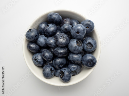 A true overhead shot of blueberries in a small white bowl.