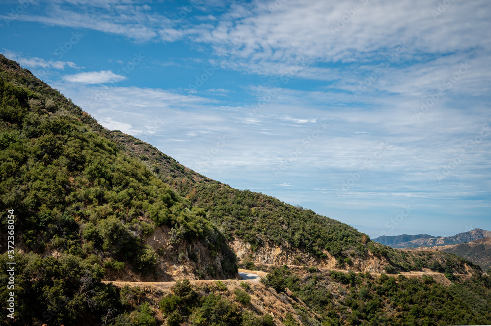 Road winding through mountains on a cloudy day