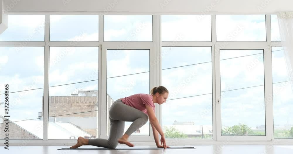 Woman practicing pigeon and split pose at yoga studio Woman practicing pigeon and split pose at yoga studio