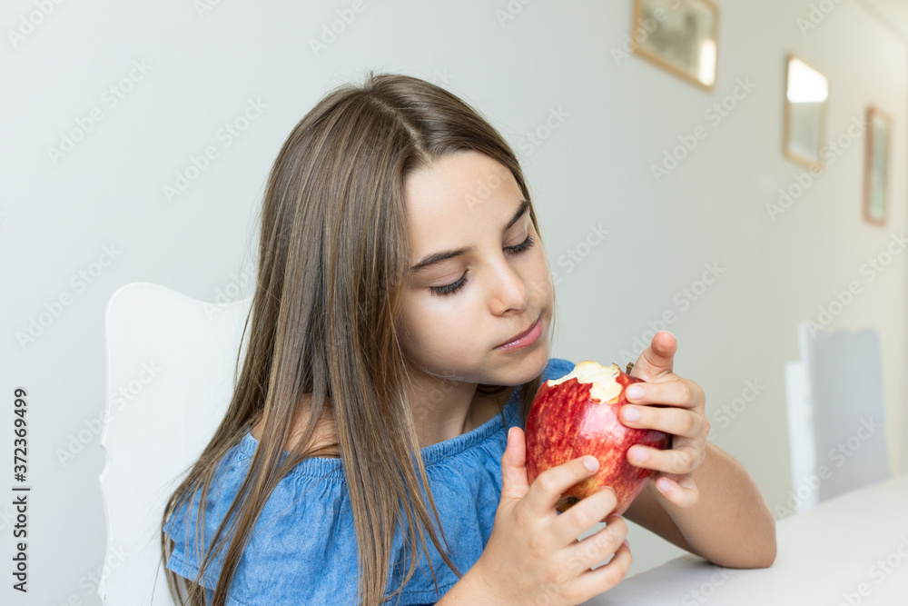 Criança saboreia maça deliciosa com expressões de satisfação Criança saboreia maça deliciosa com expressões de satisfação