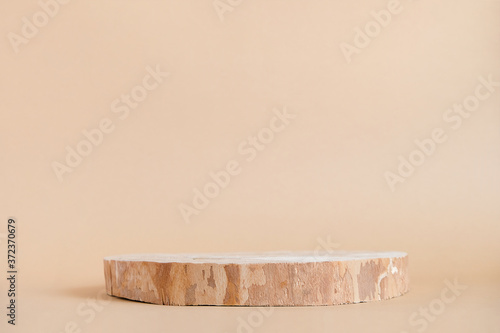 Fototapeta Naklejka Na Ścianę i Meble -  Round wooden saw cut cylinder shape on beige background abstract background. Minimal box and geometric podium. Scene with geometrical forms. Empty showcase for eco cosmetic product presentation
