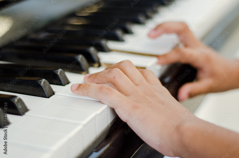 Fototapeta premium manos tocando piano, manos de joven tocando piano