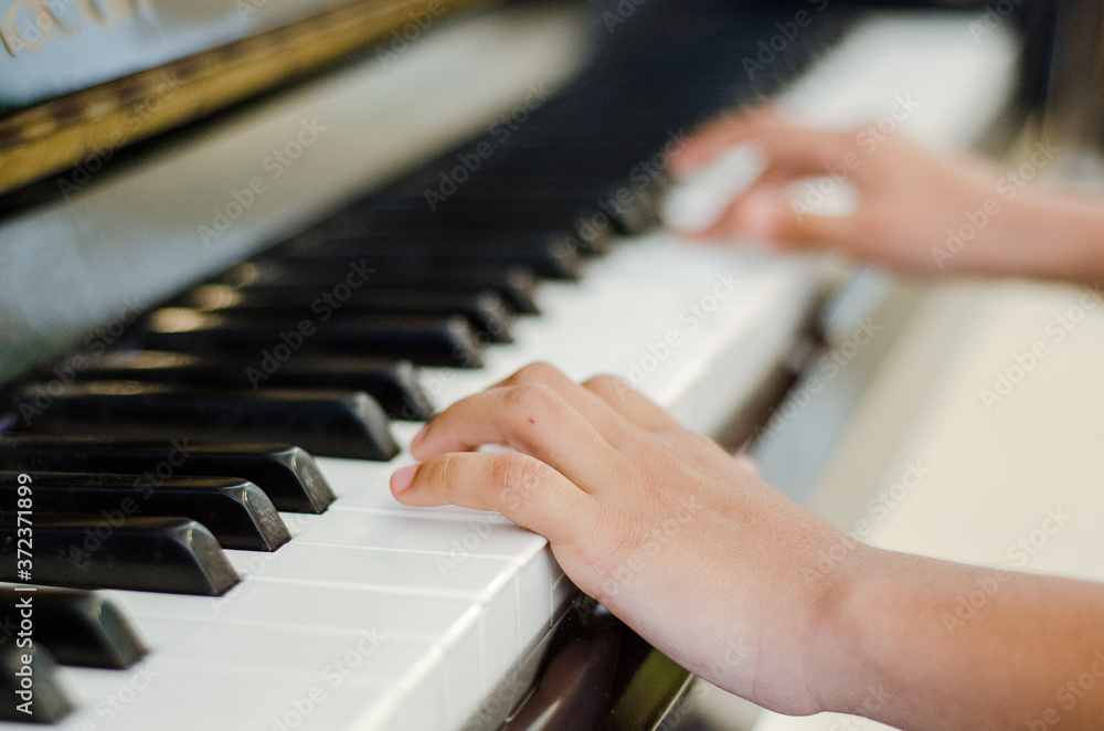 Fototapeta premium manos tocando piano, manos de joven tocando piano