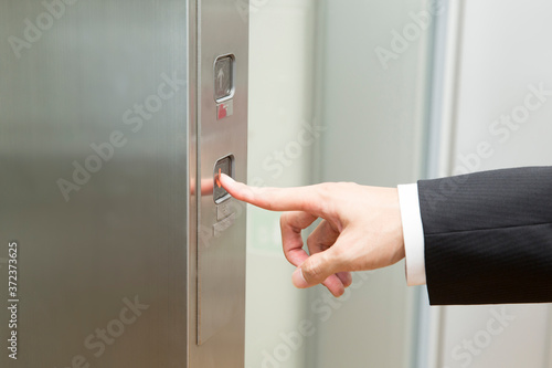エレベーターのボタンを押す手元