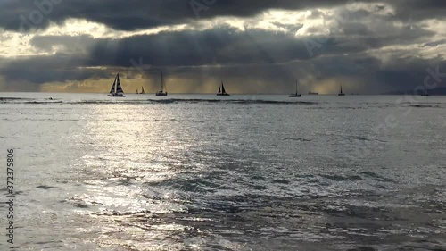 Sailboats on the horizon at sunset from Waikiki Beach, Oahu, Hawaii