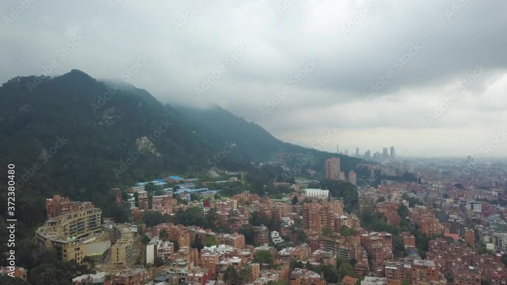 Bogota. Colombia Under Cloudy Stormy Sky. Aerial View of Downtown Neighborhood Under Monseratte Mountain, Panoramic Drone Shot Bogota. Colombia Under Cloudy Stormy Sky. Aerial View of Downtown Neighborhood Under Monseratte Mountain, Panoramic Drone Shot