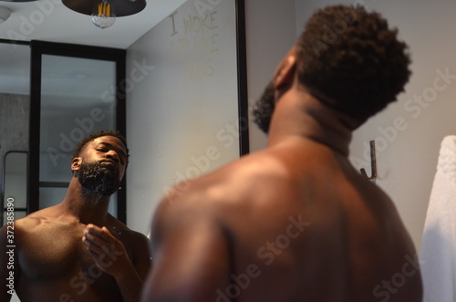 African American man looks at himself in the mirror