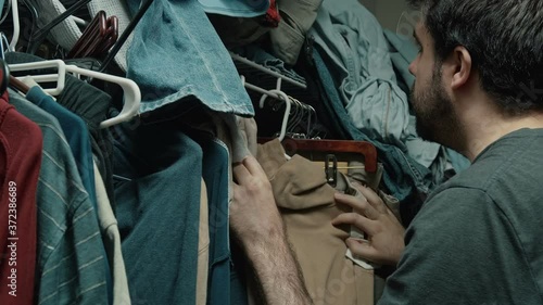 man looking for clothes in closet