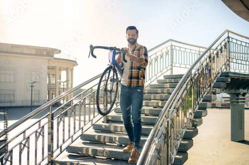 Man with bicycle descending the steps of bridge