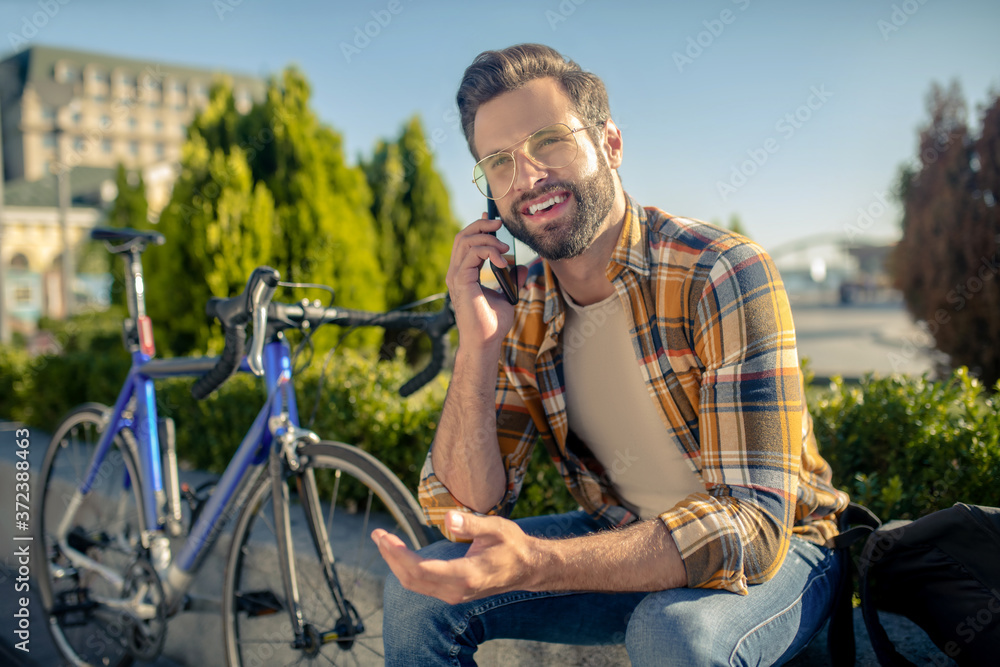 Bearded man with glasses talking on smartphone