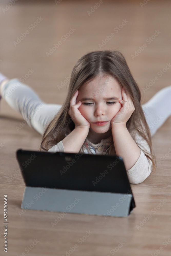 the kids are watching cartoons on the tablet. Home schooling for girls during quarantine the kids are watching cartoons on the tablet. Home schooling for girls during quarantine