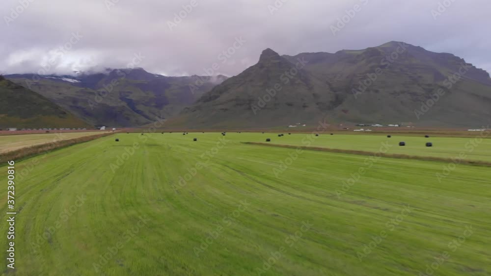 Aerial images of beautiful Icelandic crops next to high mountains and the famous Eyjafjallajökull volcano. Clouds float over the mountain peaks. The crops draw nice lines on the ground. Aerial images of beautiful Icelandic crops next to high mountains and the famous Eyjafjallajökull volcano. Clouds float over the mountain peaks. The crops draw nice lines on the ground.
