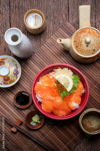 Delicious Donburi or Japanese rice bowl topped Sashimi Salmon Roe and Fish eggs on Bamboo table.