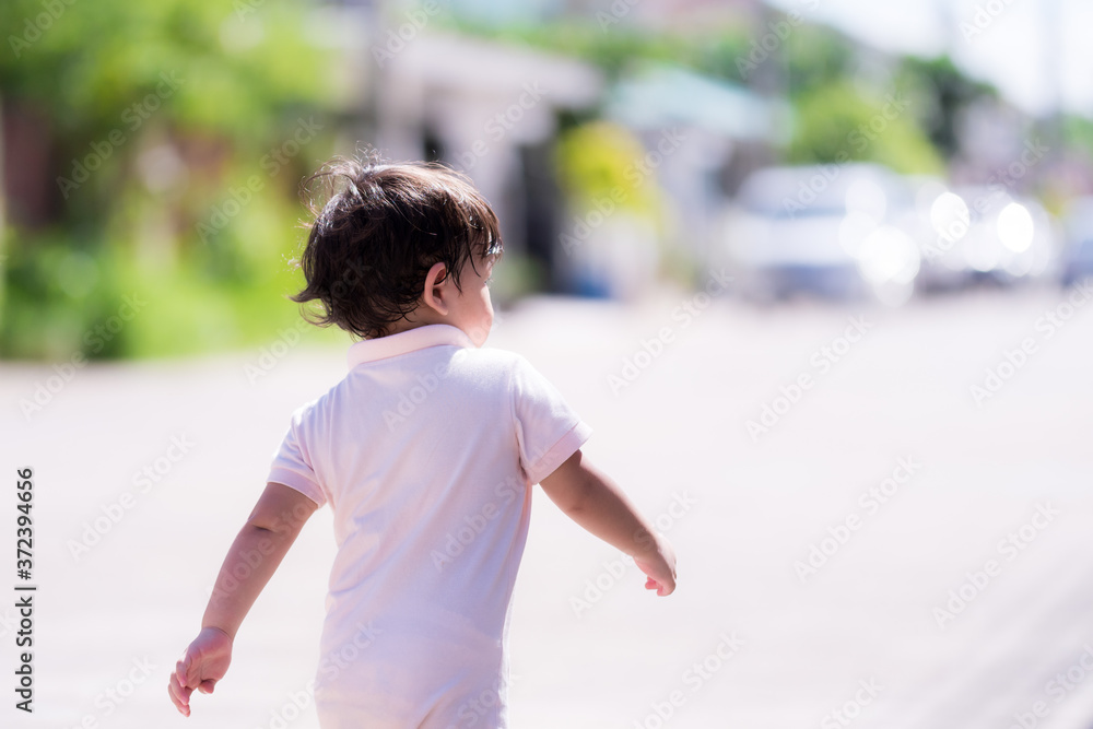 Asian toddler boy running on the street. Back side of son. Child running outside in sunny summer day. Kid funny happy healthy in the morning. Children 2 years old. Asian toddler boy running on the street. Back side of son. Child running outside in sunny summer day. Kid funny happy healthy in the morning. Children 2 years old.