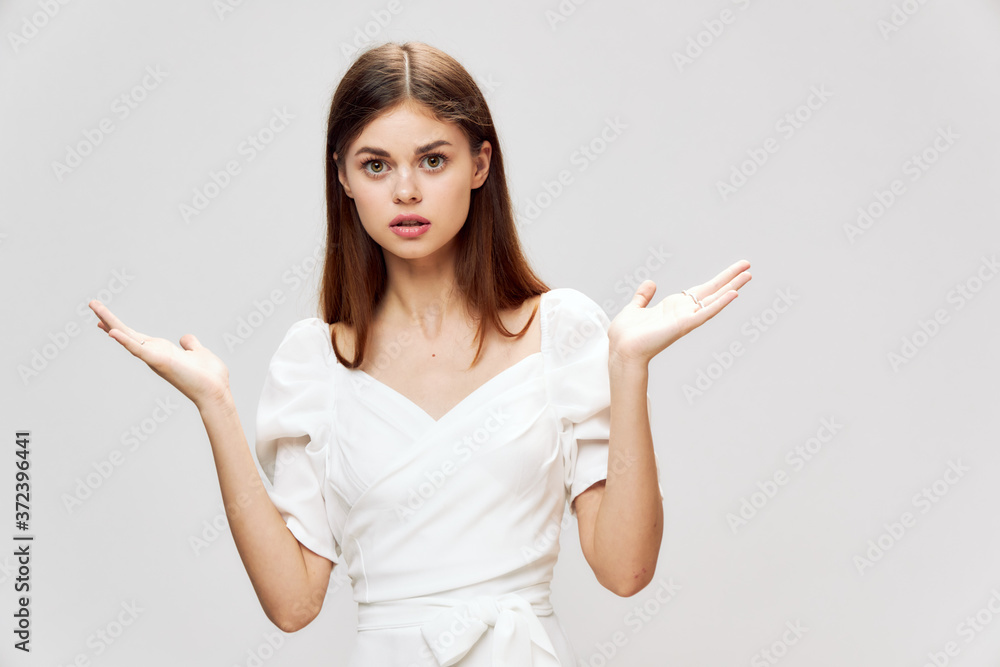 Woman in white dress holds hands in front of her palms up gray background Copy Space Woman in white dress holds hands in front of her palms up gray background Copy Space