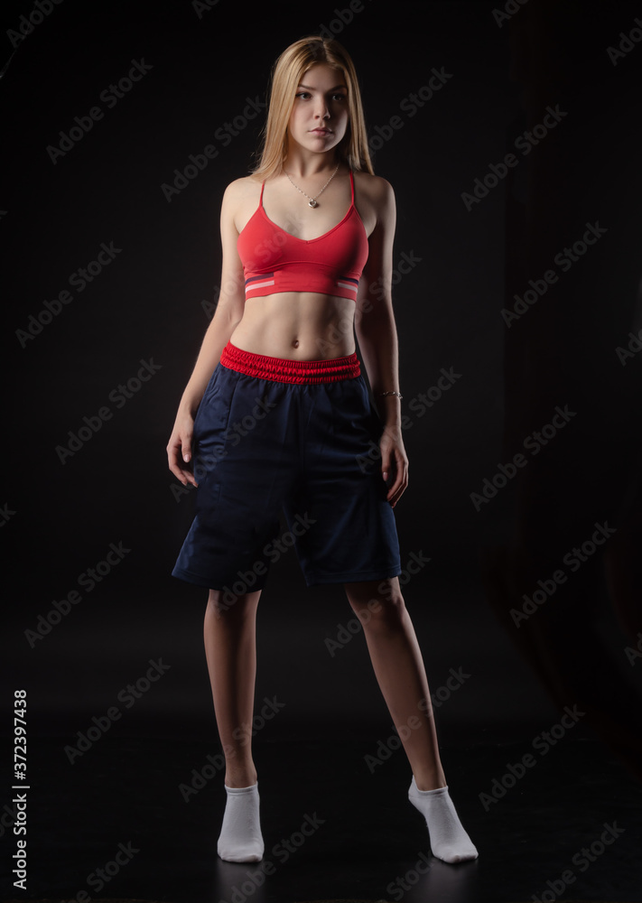 athletic girl in Boxing shorts on a black background athletic girl in Boxing shorts on a black background