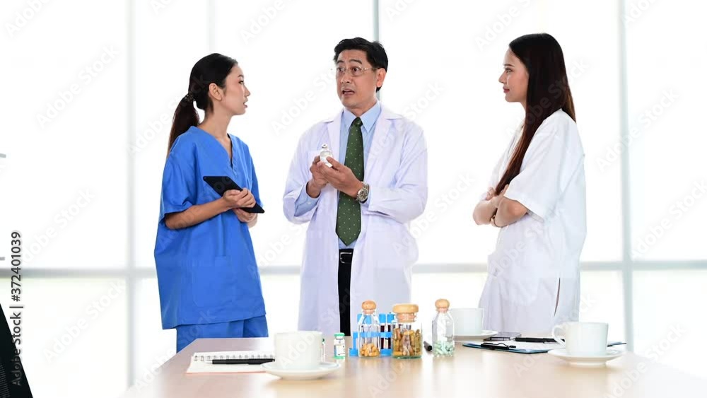 Group of doctors wearing formal white coat and blue scrubs suit, Teamwork brainstorm meeting with computer laptop at the hospital. Healthcare specialist people. Group of doctors wearing formal white coat and blue scrubs suit, Teamwork brainstorm meeting with computer laptop at the hospital. Healthcare specialist people.