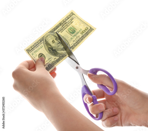 Female hands with dollar banknote and scissors on white background. Concept of bankruptcy or default photo