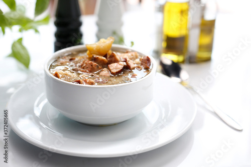 Traditional Polish sour rye soup with sausage and potatoes. Appetizing soup. Suggestion to serve the dish. Culinary photography.