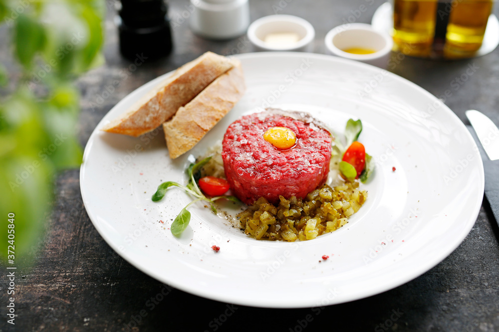 Beef tartare with egg and pickles. Appetizing appetizer. Suggestion to serve the dish. Culinary photography. Beef tartare with egg and pickles. Appetizing appetizer. Suggestion to serve the dish. Culinary photography.