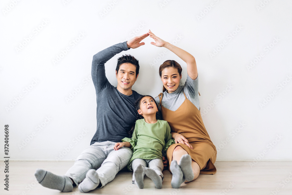 portrait enjoy happy smiling love asian family father and mother with young parents little asian girl sitting and making roof house with hands arms over head in new home