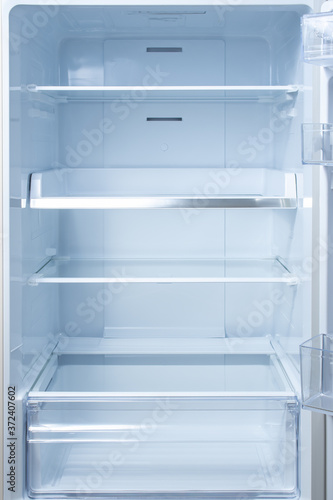 Empty open fridge with shelves, refrigerator. mockup background empty shelves for your products.