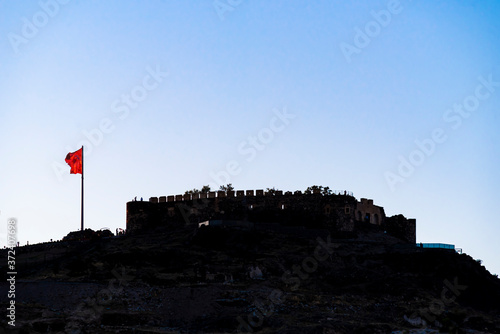 View of Nevsehir Castle at sunset with Turkish flag in Kayasehir