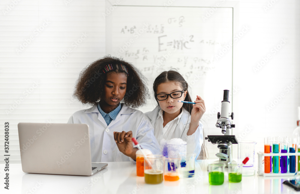 Group of teenage cute little students child learning research and doing a chemical experiment while making analyzing and mixing liquid in test tube at experiment laboratory class at school.Education Group of teenage cute little students child learning research and doing a chemical experiment while making analyzing and mixing liquid in test tube at experiment laboratory class at school.Education