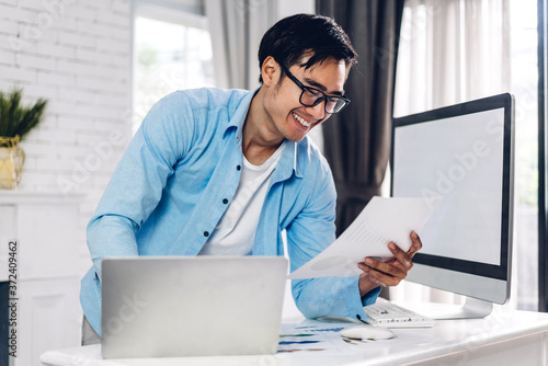 Young creative man relaxing using desktop computer working and video conference meeting online chat at home.work from home concept