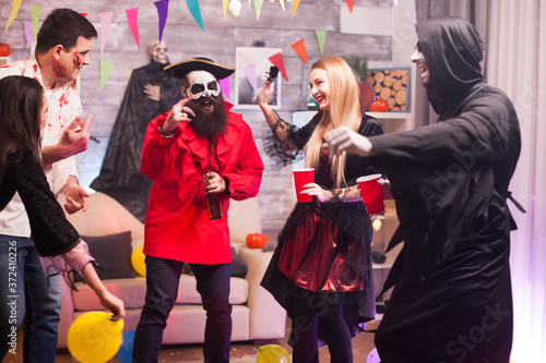 Grim reaper and pirate dancing while celebrating halloween . Spooky costumes.