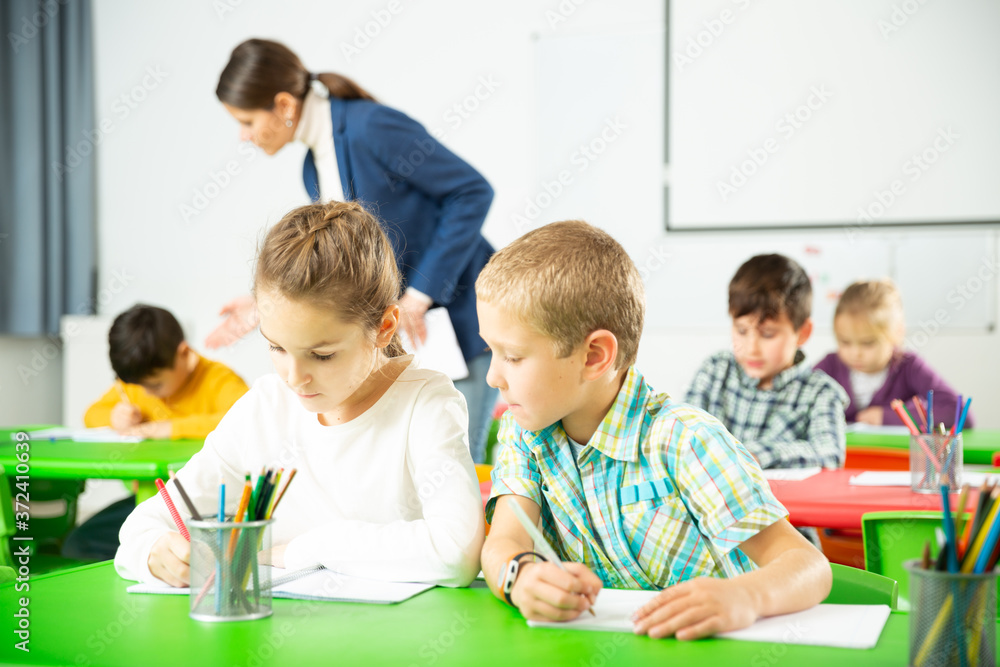 Happy pupils chattering sitting at lesson in elementary school. High quality photo