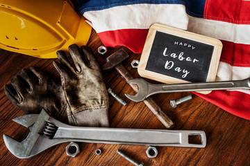 American National Holiday. US Flags with American stars, stripes and national colors. Construction and manufacturing tools on wooden background. Labor day background concept.