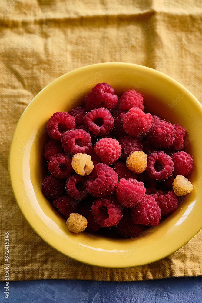 Raspberries in a yellow plate. Copy space. Raspberries in a yellow plate. Copy space.