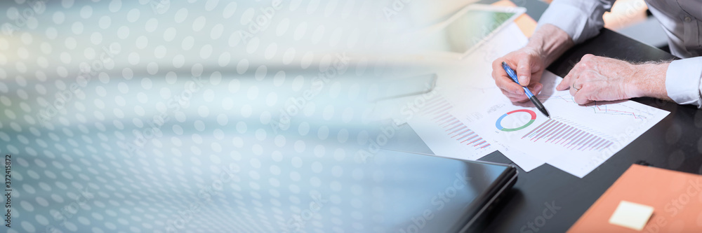 Businessman analyzing graphics, light effect; panoramic banner Businessman analyzing graphics, light effect; panoramic banner