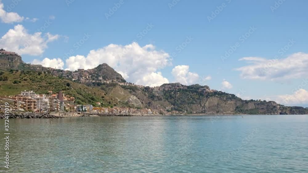 View from Giardini Naxos at an ancient Taormina town on a hill in Sicily View from Giardini Naxos at an ancient Taormina town on a hill in Sicily