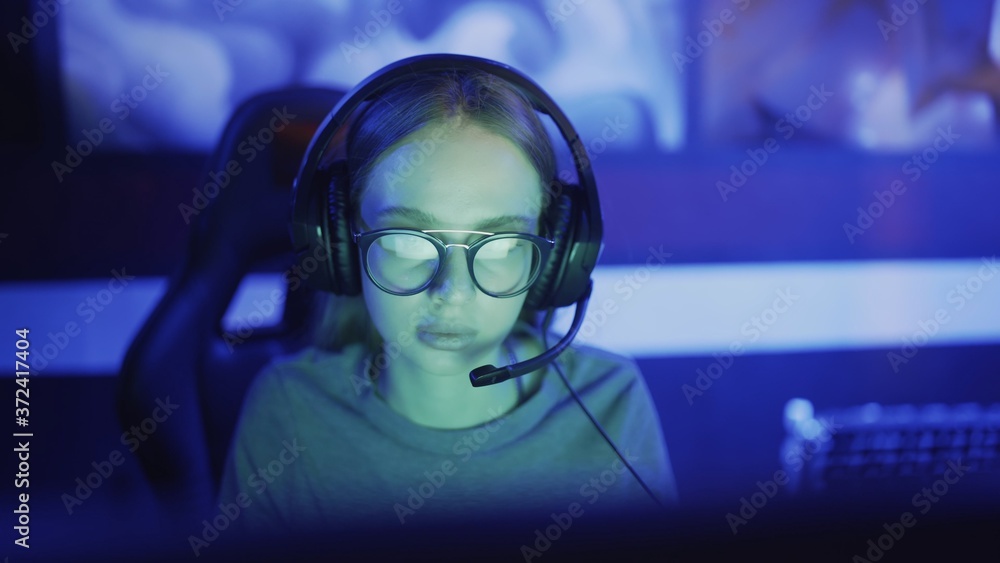 Close-up on the Hands of the Girl Gamer Playing in the Video Game Using Keyboard. Female Hacker Breaks into System. Background with Cool Neon Lights. Close-up on the Hands of the Girl Gamer Playing in the Video Game Using Keyboard. Female Hacker Breaks into System. Background with Cool Neon Lights.