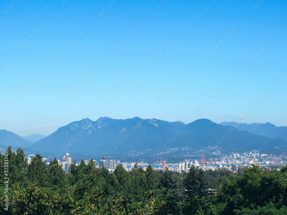 Vancouver skyline and mountains seen from Queen Elizabeth Park on a sunny summer day.