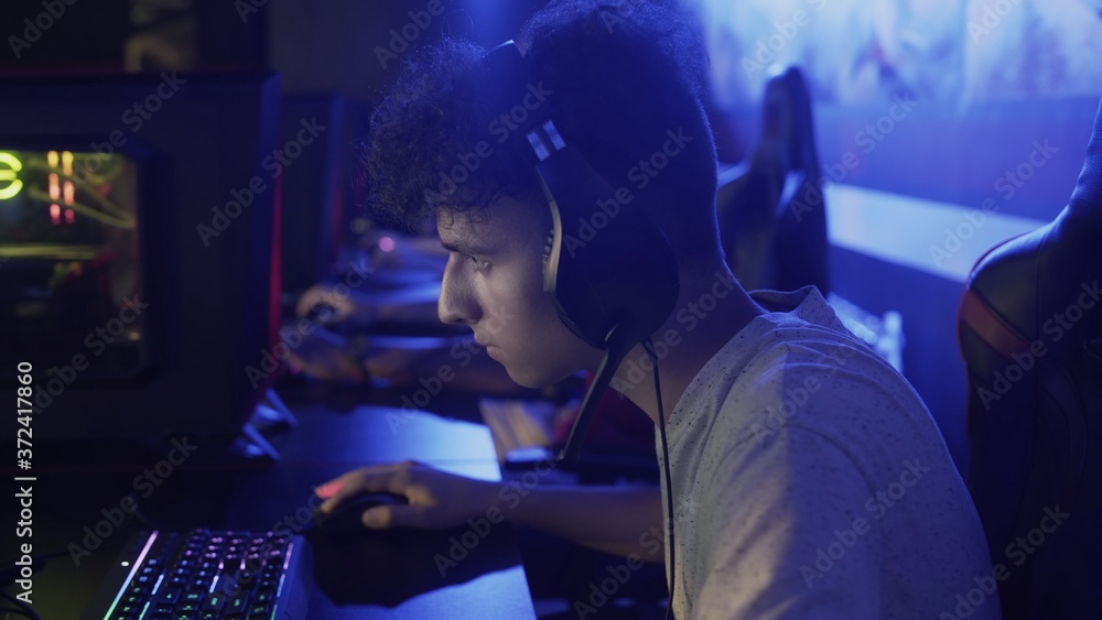 Concentrated young man sits in front of monitor and loses hard level in video game in computer club Concentrated young man sits in front of monitor and loses hard level in video game in computer club