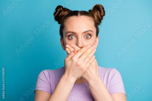 Closeup photo of crazy pretty shocked lady two buns hold arms on mouth look speechless said wrong thing bad situation wear casual purple t-shirt isolated blue color background
