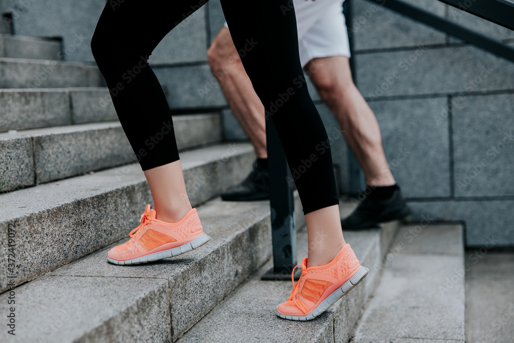 man's and woman's feet in sportshoes doing workout on the street, climbing up the stairs, healthy fit lifestyle man's and woman's feet in sportshoes doing workout on the street, climbing up the stairs, healthy fit lifestyle