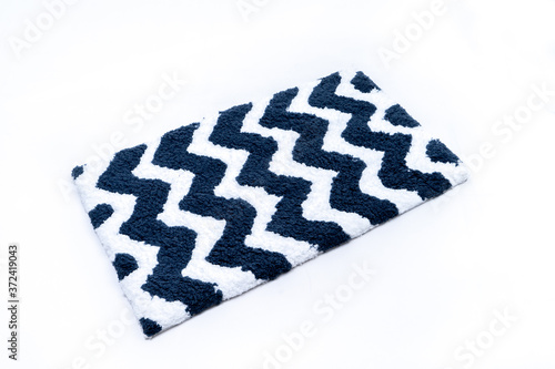 Flat lay, black and white color with zig zag pattern of microfiber bath mat isolated on white background