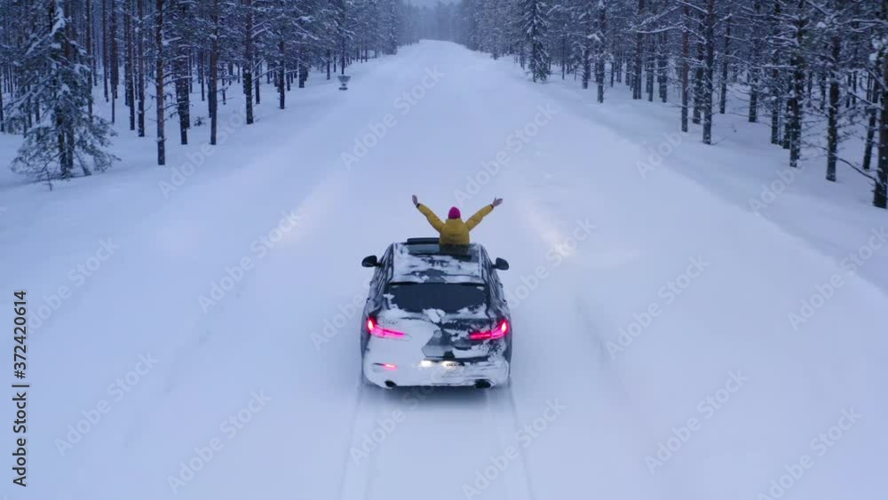 Bird's eye view, female tourist into hatch of car raised arms enjoying winter trip in north country while driving on snowy road surrounded by coniferous forest. Wanderlust in journey, freedom in life
Bird's eye view, female tourist into hatch of car raised arms enjoying winter trip in north country while driving on snowy road surrounded by coniferous forest. Wanderlust in journey, freedom in life