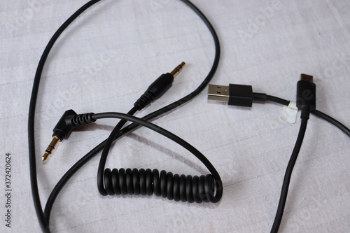Wires and cables of the common electronic devices. Headphone jack and connectors lying on the table.